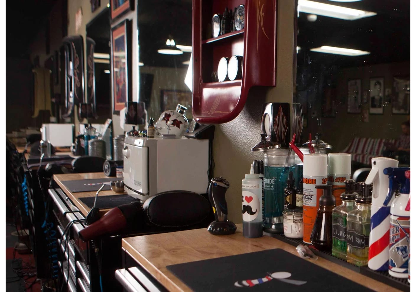 Barber station detail with grooming products, clippers, and mirrors